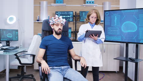 Female-doctor-checking-the-brain-activity-of-male-patient