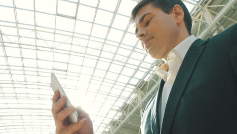 Businessman-with-Smartphone-in-Modern-Building
