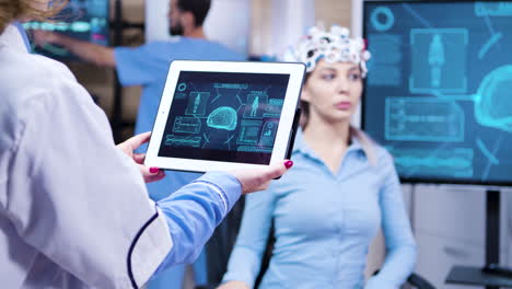 Middle-age-female-doctor-holding-tablet-with-patient-brain-activity