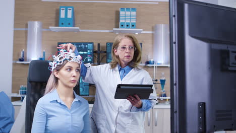 Dolly-shot-of-female-doctor-checking-brain-activity-of-her-female-patient