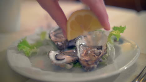 Pouring-lemon-juice-on-oysters