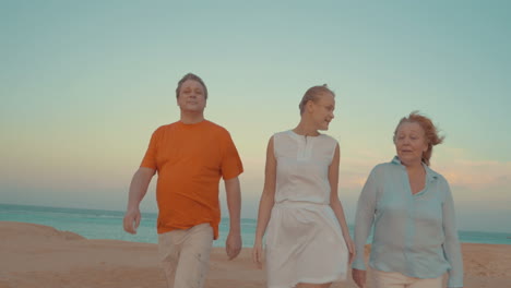 Young-woman-and-parents-walking-on-beach
