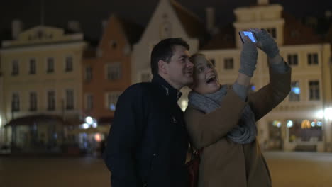 Glückliches-Paar-Macht-Telefon-Selfie-In-Der-Abendstraße