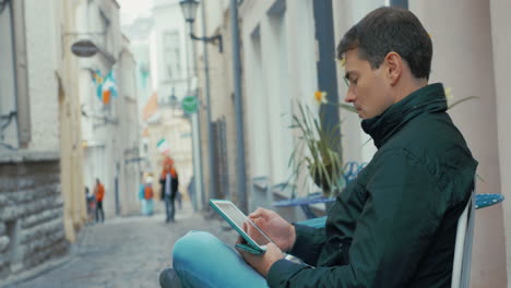 Erwachsener-Mann-Mit-Tablet-Computer-Sitzt-Auf-Der-Straße