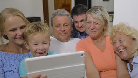 Family-with-child-watching-interesting-video-on-pad