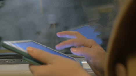 Tablet-In-Den-Händen-Eines-U-Bahn-Passagiers