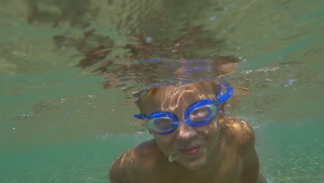 Boy-in-Goggles-Swimming-Under-the-Sea-Water