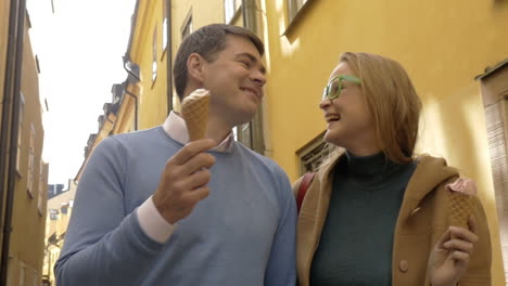 Happy-man-and-woman-eating-ice-cream-during-a-walk