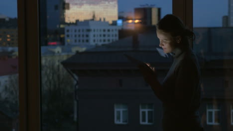 Girl-working-with-pad-by-the-window-at-night