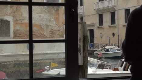 Woman-enjoying-Venice-scene-from-the-window
