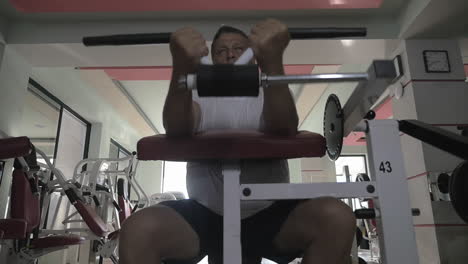 Senior-man-doing-exercise-on-training-machine-in-gym