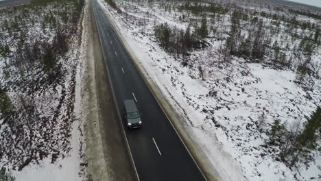 Aerial-view-of-minivan-driving-winter-road