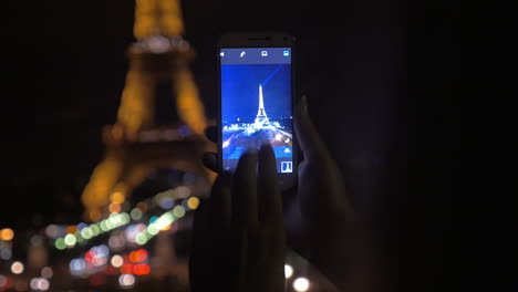 Tomando-Una-Foto-De-La-Torre-Eiffel-Con-El-Móvil-Por-La-Noche
