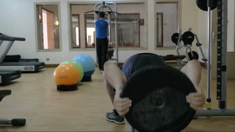 Zwei-Männer-Trainieren-Mit-Sportgeräten-Im-Fitnessstudio