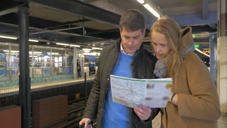 Paar-Reisende-Mit-Karte-In-Der-U-Bahn