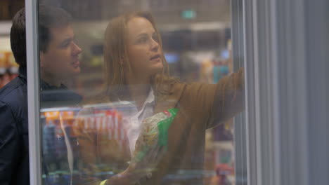 Young-Couple-Picking-Food-from-the-Store-Freezer