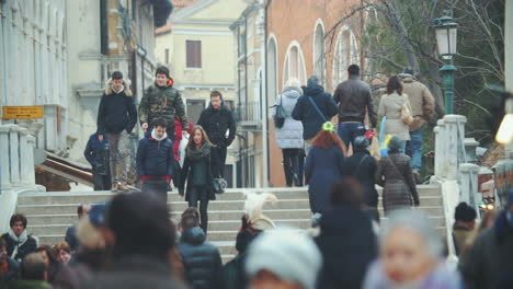 Venetian-street-view-with-people-walking-across-the-bridge