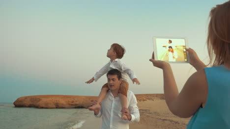 Mother-with-pad-shooting-father-and-son-on-beach