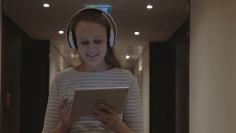 Woman-with-pad-enjoying-music-in-headphones