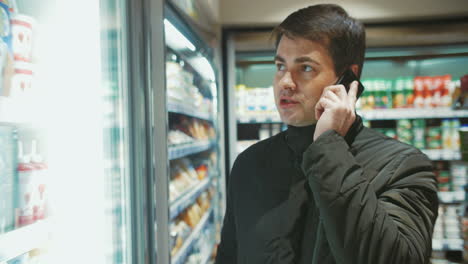 Hombre-Hablando-Por-Teléfono-En-La-Tienda-De-Alimentos
