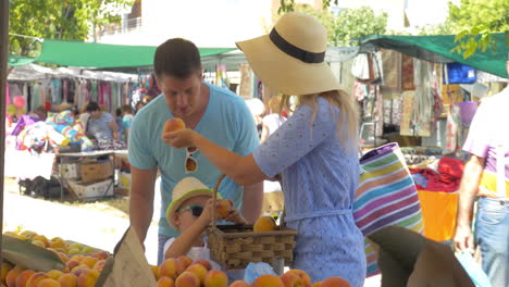 Young-family-in-market-of-Thessaloniki-Greece-choose-peaches