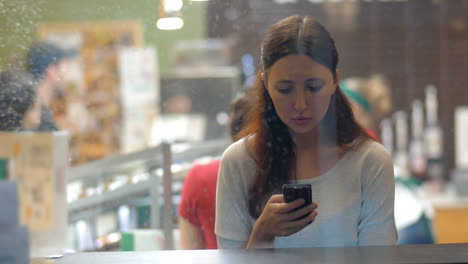 Woman-exchanging-messages-on-cell-in-cafe