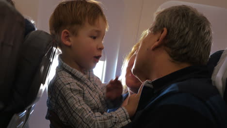 Child-exploring-grandfathers-face-in-the-plane