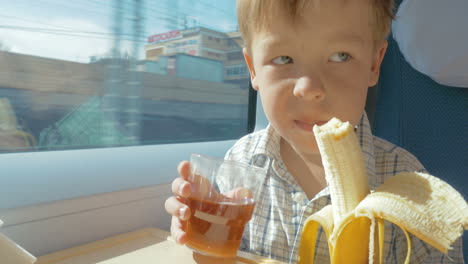 Little-boy-eats-while-travelling-by-train