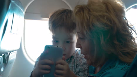 Großmutter-Und-Enkel-Mit-Handy-Im-Flugzeug
