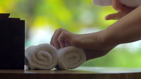 Placing-fresh-towels-with-flower-on-the-table-in-spa
