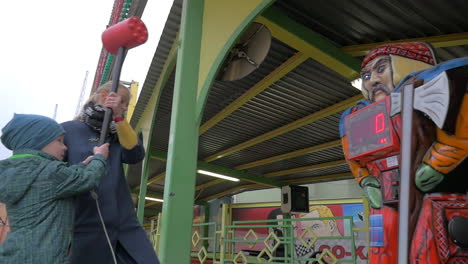 Slow-motion-view-of-mother-with-son-hitting-with-toy-hammer-game-in-amusement-park-Vienna-Austria