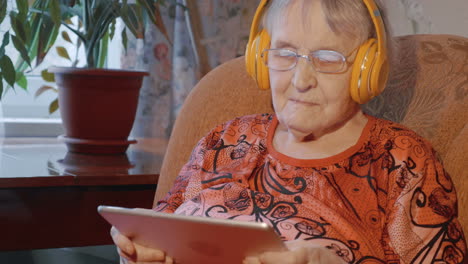 Grandmother-using-touch-pad-in-wireless-headphones