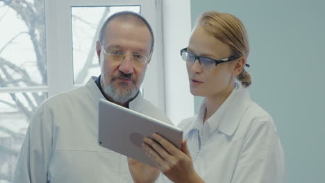 Two-doctors-having-professional-talk-using-touch-pad