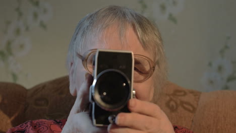 Elderly-woman-with-retro-camera-at-home