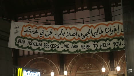 Banner-Liebe-Asylbewerber,-Wir-Sind-Hier,-Um-Ihnen-In-Englischer-Und-Arabischer-Schrift-Zu-Helfen
