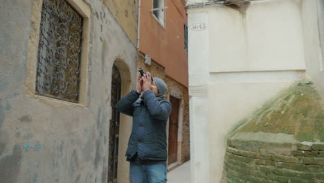 Man-filming-old-architecture-with-retro-camera