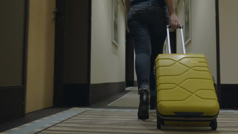 Woman-with-trolley-bag-looking-for-room-in-hotel