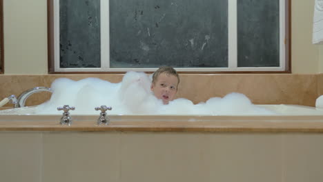 Playful-child-having-bath-with-foam