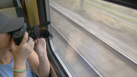 Young-girl-going-by-train-and-taking-pictures