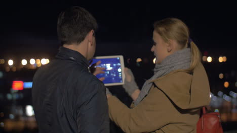 Couple-Taking-Photos-of-Night-City-with-Tablet-PC
