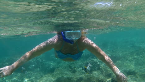 Woman-in-snorkel-diving-and-waving-with-hands