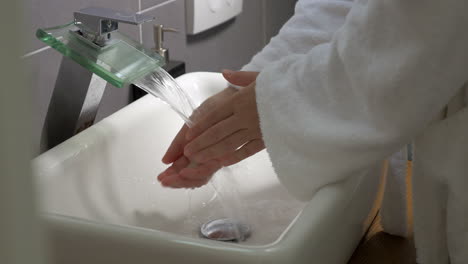Woman-washing-hands-with-soap-in-the-bathroom