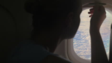 Woman-looking-out-illuminator-in-plane