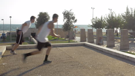 Two-young-parkour-athletes-showing-skills