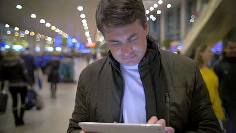 Man-using-electronic-tablet-at-the-station