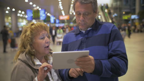 Älteres-Paar-Mit-Touchpad-Am-Flughafen