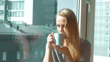Woman-Drinking-Morning-Tea-by-Window