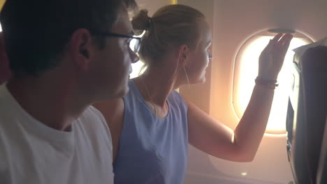 Frau-Und-Mann-Schauen-Aus-Dem-Flugzeugfenster