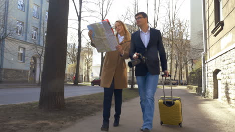 Young-couple-going-sightseeing-with-camera-and-map