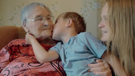 Little-boy-expressing-love-to-mother-and-grandmother-with-kisses